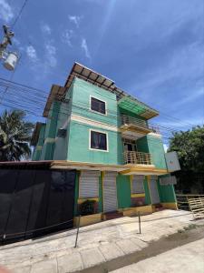 a blue and green house on a street at Princesa el gallo inn in Puerto Princesa City