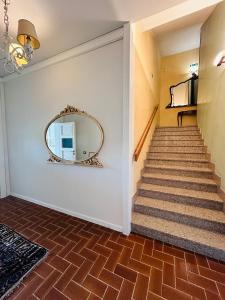 ein Flur mit einem Spiegel an der Wand und einer Treppe in der Unterkunft MH Hotel Merica in Sommacampagna