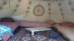 a room with two beds and a table in a tent at Le tipi Naskapi in Trans-en-Provence