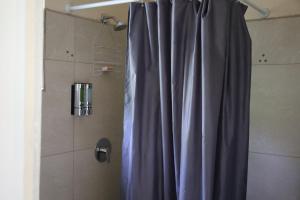 bagno con doccia con tenda blu di My Gem in the Caribbean a Castries