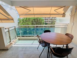 a table and chairs in a room with a balcony at Appartements de Standing Cannes Centre in Cannes
