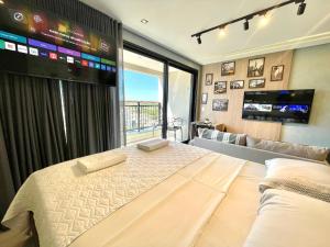 a bedroom with a large bed with a large screen at A Melhor Vista com Academia no Rooftop in Campo Grande +24 photos