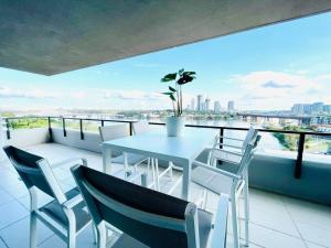 a white table and chairs on a balcony with a view at Stunning waterfront 3 bedroom condo with Pool, BBQ in Sydney