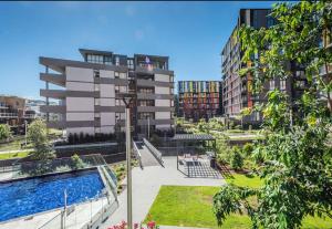 a building with a swimming pool in a city at Stunning waterfront 3 bedroom condo with Pool, BBQ in Sydney