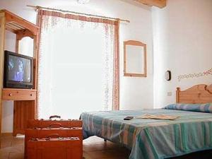 sypialnia z łóżkiem i telewizorem w obiekcie Hotel Garni Tosca w mieście Lido di Jesolo