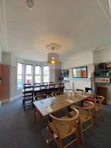 a dining room with a large wooden table and chairs at Hayward's at the Grasmere in Keynsham