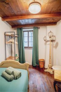 a bedroom with a bed with green curtains and a lamp at La Casa Dell'Artista in Rossaza +35 photos