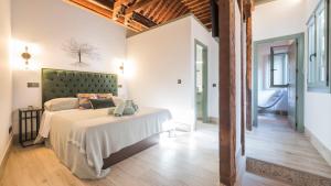 Un dormitorio con una cama con cabecero verde. en Luxury Los Olivos de San Ginés - Living Toledo, en Toledo