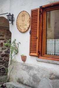 a wooden sign on a wall next to a window at La Casa Dell'Artista in Rossaza
