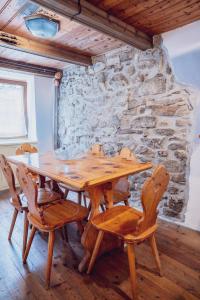 a wooden table and chairs in a room with a stone wall at La Casa Dell'Artista in Rossaza