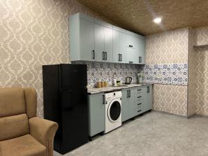 a kitchen with a refrigerator and a washing machine at Apartment Gira In Mestia in Mestia