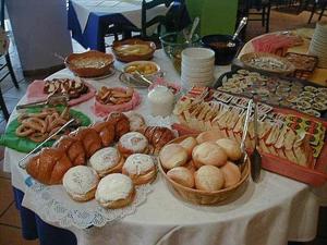 リド・ディ・イエゾロにあるHotel Garni Toscaの様々な種類のドーナツやペストリーを揃えたテーブル