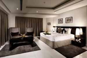 a bedroom with a large bed and two chairs at Aswar Al olaya for serviced Apartments in Al Khobar +18 photos