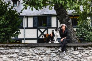 a man and a dog sitting next to a tree at La Sainthilarienne in Saint-Lary-Soulan +75 photos