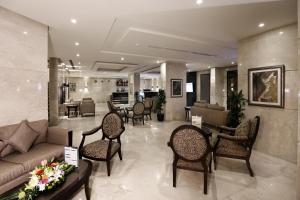 een woonkamer met een bank en stoelen bij Aswar Al olaya for serviced Apartments in Al Khobar +21 foto's
