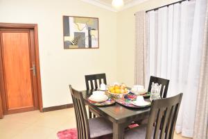 a dining room table with a bowl of fruit on it at Kaizen Residences in Entebbe