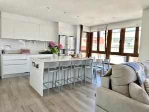 a kitchen with white cabinets and a kitchen island at Apartamento Somo Playa con garaje, Cantabria in Somo