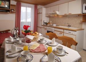 Una cocina con una mesa con comida encima. en Haus Lärchenheim, en Wagrain