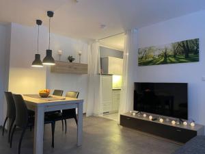 a dining room with a table and chairs and a television at Ferienwohnung zum Zauberwald in Marsberg