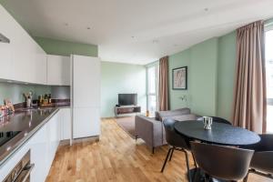 a kitchen and living room with a table and chairs at Native Victoria in London