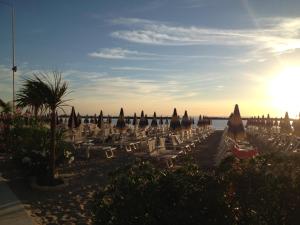 Hotel San Salvador في بيلاريا-إيجيا مارينا: مجموعة من الكراسي والمظلات على الشاطئ