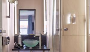 a bathroom with a green bowl sink and a shower at Flemings Hotel München-Schwabing in Munich