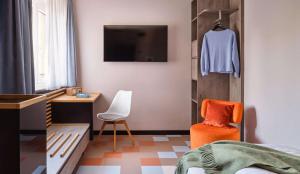 a bedroom with a bed and a tv and a chair at Flemings Hotel München-Schwabing in Munich +80 photos