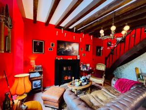 a living room with red walls and a leather couch at La maison sur demande - Harry Potter - Ciné Room in Mazangé