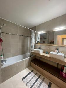 a bathroom with two sinks and a bath tub at Appartement Cosy in Saint-Gratien