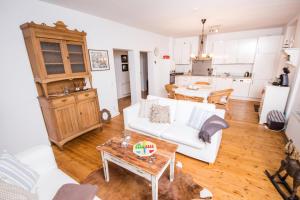 a living room with a white couch and a table at Ferienwohnung Wagner in Saarburg