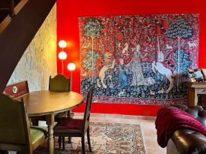 a room with a red wall with a tapestry at La maison sur demande - Harry Potter - Ciné Room in Mazangé