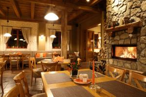 a restaurant with a fireplace and tables and chairs at Hotel a restaurace Palfrig in Stará Ves nad Ondřejnicí