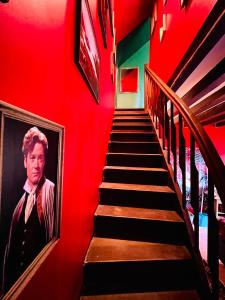 a staircase with a painting of a man on the wall at La maison sur demande - Harry Potter - Ciné Room in Mazangé