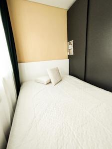 a white bed in a room with a window at Cozy A Noko Apartment in Murava