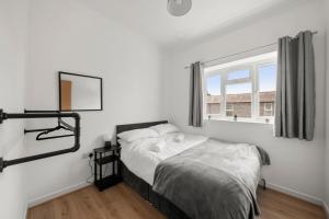 - une chambre avec un lit aux murs blancs et une fenêtre dans l'établissement Central Reading - 3 bed apartment, à Reading