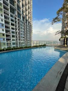 a swimming pool in front of a tall building at Aurora Staycation I-City Shah Alam in Kampong Padang Jawa