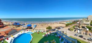 Una vista de la playa desde el balcón de un resort. en Hotel Coliseo, en Villa Gesell