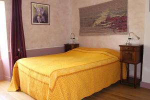 a bedroom with a yellow bed and a night stand at Chez Germaine in Les Granges-Gontardes +9 photos