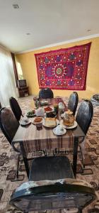 a table with plates of food on it in a room at Sim-Sim Hostel in Panjakent