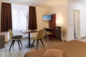 Habitación de hotel con cama, mesa y sillas en Gästehaus Stiftsstadt, en Kempten