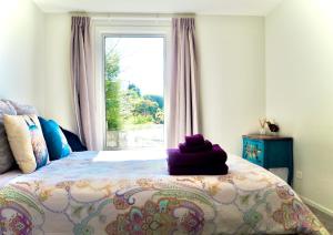 ein Schlafzimmer mit einem Bett mit einem großen Fenster in der Unterkunft Queenstown Villa with Amazing Lake Views & floor heating 湖景别墅 & 地暖 in Queenstown