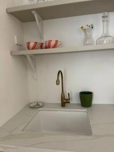 a kitchen counter with a sink and a shelf at Captains Rest St Kilda West in Melbourne +4 photos