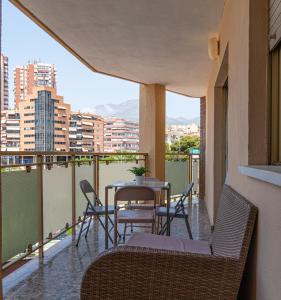 贝尼多姆Garay Apartments的配有桌椅的阳台，可欣赏城市景观 更多220张照片