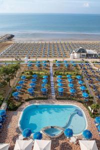 z góry widok na ośrodek z basenem i plażę w obiekcie Regent's Hotel w mieście Lido di Jesolo