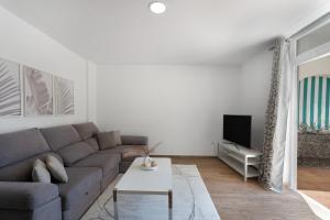 a living room with a couch and a tv at Beach Holidays in Adeje