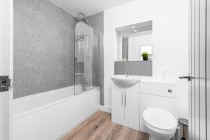 Un baño blanco con inodoro y lavabo. en Two Bedroom Apartment - Balcony - Secure Parking - Top Rated - Underfloor Heating - 2MC, en Birmingham