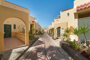 a street in a resort with buildings and palm trees at Beach Holidays in Adeje