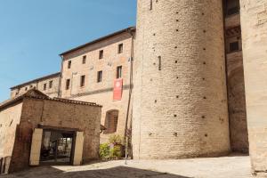 a building with two large brick towers with a doorway at Residenza Antica Canonica in Città di Castello