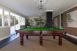 Una sala de estar con una mesa de billar y una lámpara de araña. en Brisbane Hamilton Hill With Panorama View, en Brisbane