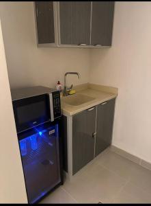 una piccola cucina con lavello e microonde di استديو بموقع مميز بدخـول ذاتي a Riyad